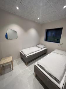 1 dormitorio con 2 camas y TV de pantalla plana en Kalsoy cottages - Jogvansstova, 