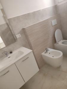 Baño blanco con aseo y lavamanos en B & B CANTARANO, en Porto Garibaldi