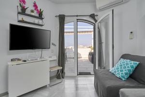 een woonkamer met een tv en een bank bij One Bedroom Penthouse in Nerja