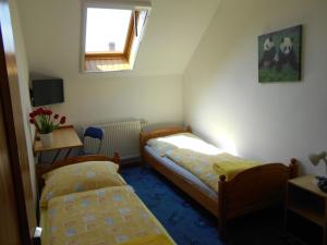 Duas camas num pequeno quarto com uma janela em Árpád Panzió em Gyor