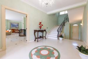 ein großes Wohnzimmer mit einer Treppe und einem Teppich in der Unterkunft Villa Frida - Piscina privata ed Eventi a Lecce in San Pietro in Lama