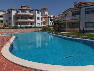uma grande piscina em frente a alguns edifícios em Apartamento em D'el Rey-Obidos Beach & Surf em Amoreira