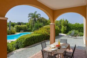 un patio con mesa, sillas y piscina en Villa Frida - Piscina privata ed Eventi a Lecce, en San Pietro in Lama