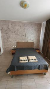 een slaapkamer met een bed en een stenen muur bij Casa Razvan Vama Veche in Vama Veche