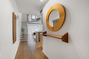 a hallway with a mirror on the wall and a staircase at Gaudi Beach view in Tel Aviv