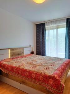 a bedroom with a large bed with a window at Olympia Apartment in Latschach ober dem Faakersee