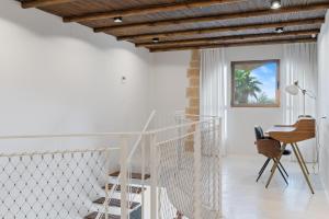 a white staircase in a room with a table and chairs at Gaudi Beach view in Tel Aviv