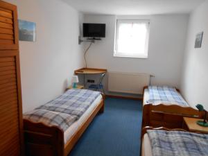 a room with two beds and a desk and a window at Árpád Panzió in Győr