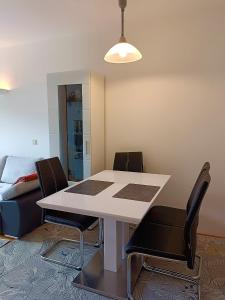 een eetkamer met een witte tafel en stoelen bij Olympia Apartment in Latschach ober dem Faakersee