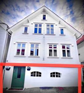 a white house with a green door on a street at The Green Door H1 in Stavanger