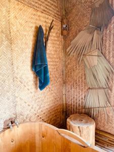 Sa Pả的住宿－maison Rose & Jardinier eco homestay，浴室配有浴缸和墙上的两把遮阳伞