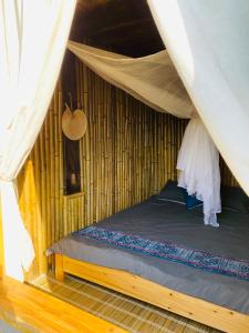 a bedroom with a bed in a hut at maison Rose & Jardinier eco homestay in Sa Pả