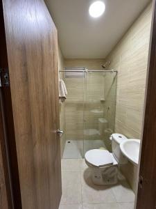a bathroom with a toilet and a glass shower at Apto-Parking cerca CC Gran Plaza in Pitalito