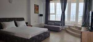a bedroom with a bed and a couch and a chair at Vila DVG Costinesti in Costinesti