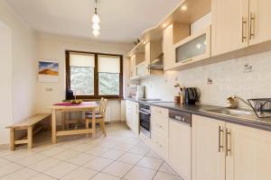 een keuken met witte kasten en een tafel en een tafel bij Willa Marta Zakopane in Zakopane +68 foto's