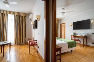 een hotelkamer met een bed en een tv bij Hotel Hernán Cortés in Gijón