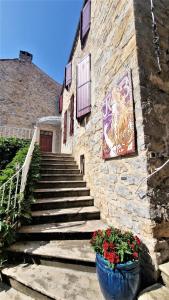 a stone building with stairs and flowers in front of it at Les GARGOUILLES Gorges du Tarn - Millau in Boyne