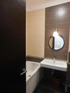 y baño con lavabo, bañera y espejo. en Apartment Keymaster's Hideaway, en Liubliana