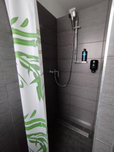 a bathroom with a shower with green leaves on the wall at UBYTOVŇA BYTČA in Bytca