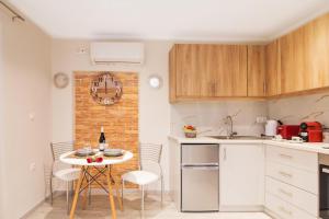 a kitchen with a table and chairs in a kitchen at Olimpias Nest Corfu in Corfu