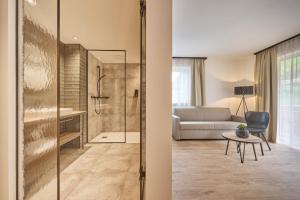 a bathroom with a shower and a living room at Alpendorf Hotel Stern in Sankt Johann im Pongau