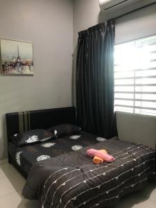 a bedroom with a bed and a window with black curtains at Ipoh Water Front City Homestay in Ipoh