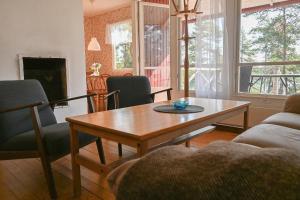 a living room with a wooden table and chairs at Rolfskärrs Stugby in Nygård