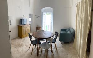 een woonkamer met een tafel, stoelen en een bank bij Dimora le Picciose in Ostuni