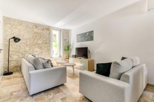 a living room with two couches and a tv at Grande villa de charme proche de la mer in Peyriac-de-Mer