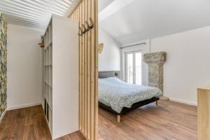 a bedroom with a bed and a book shelf at Grande villa de charme proche de la mer in Peyriac-de-Mer