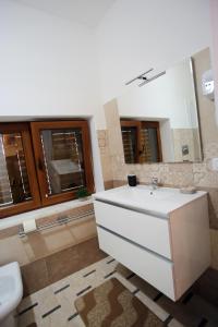ein Badezimmer mit einem weißen Waschbecken und einem Spiegel in der Unterkunft Al Centro in Gangi