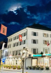 duży biały budynek z czerwonym krzyżem w obiekcie Hotel Stadthof Glarus w mieście Glarus
