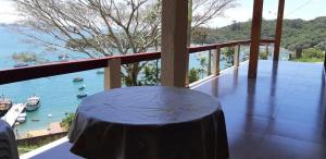 a table on a balcony with a view of the water at Marques Home in Porto Belo