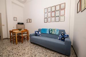 a living room with a blue couch and a table at Casa Vacanze Cattolica in Cattolica