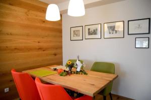 jadalnia z drewnianym stołem i krzesłami w obiekcie Spa & Wellness Apartment Gerda w mieście Grinzens