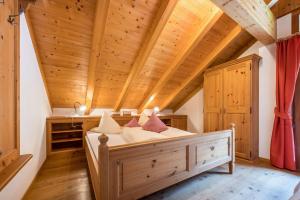 a bed in a room with a wooden ceiling at Mitterbruggehof Apt Silberdistel in Anterselva di Mezzo