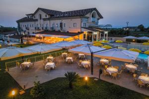 an outdoor patio with tables and umbrellas in front of a building at Hotel Insonnia in Agropoli