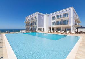 a swimming pool in front of a building at Ocean View Apartments in Lourinhã