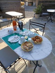 un tavolo bianco con pane e dolci di Auberge du Vieux Tour Le Manoir a Canapville