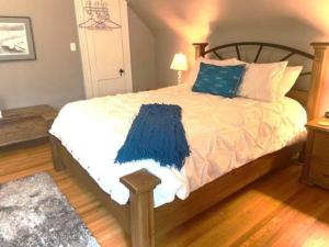 a bedroom with a bed with a blue blanket on it at Cottage on Caledonia Bed & Breakfast in Stratford