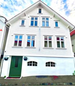 una gran casa blanca con una puerta verde en The Green Door H2 en Stavanger