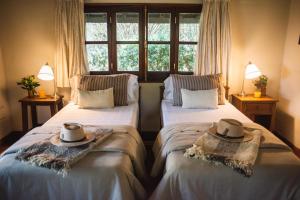 two beds in a room with hats on them at Rincón del Socorro in Uguay