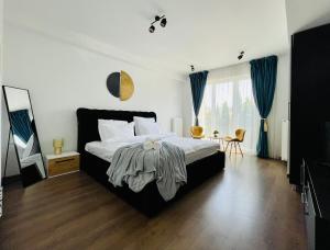 a bedroom with a large bed with blue curtains at Aventurescu Studio Brasov Coresi in Braşov
