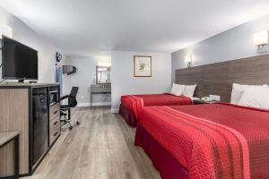 um quarto de hotel com duas camas e uma televisão de ecrã plano em Captains Quarters Motel & Conference Center em Eastham