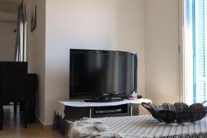 uma sala de estar com uma televisão de ecrã plano sobre uma mesa em Ateni House em Agios Petros