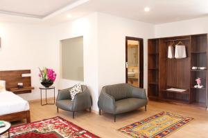 una camera d'albergo con due sedie e un letto di Hotel Mayto a Thimphu