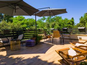 eine Terrasse mit Stühlen, Tischen und Sonnenschirmen in der Unterkunft Residence ǁ Corino in Biograd na Moru