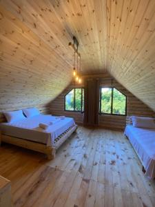 een grote kamer met 2 bedden en houten vloeren bij Guest House on Angisa in Batoemi