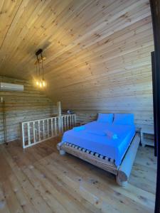 a bedroom with a bed in a wooden room at Guest House on Angisa in Batumi