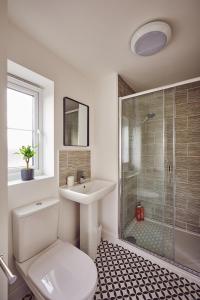 a bathroom with a toilet and a sink and a shower at Coventry Home for 6+2, 150Mbp Wi-Fi + Parking in Canley